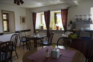 un comedor con mesas, sillas y ventanas en Gasthof Adler, en Schillingsfürst