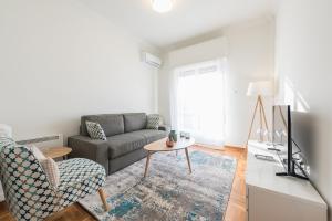 ein Wohnzimmer mit einem Sofa und einem Tisch in der Unterkunft Cozy and fresh apt close to Metro in Athen