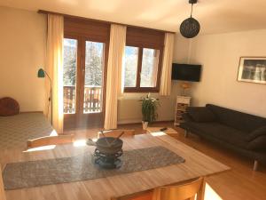 un soggiorno con un divano e un tavolo di Lärchenwald Lodge a Bellwald