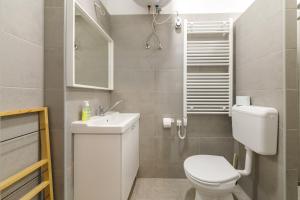 a bathroom with a white toilet and a sink at Cozy modern space at the heart of the city in Debrecen