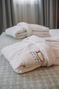 three white towels sitting on top of a bed at Hotel Dom Carlos Liberty in Lisbon