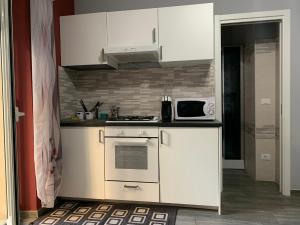 a kitchen with white cabinets and a microwave at Casa di Ema in Sanremo