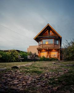 una casa de madera con un banco delante en Espejos de monte en San Miguel del Monte