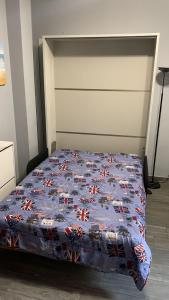 a bed with a blue quilt on it in a room at Casa di Ema in Sanremo