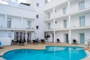 un hotel con piscina frente a un edificio en INNER Hotel Rupit "Adults Only" en Cala d´Or