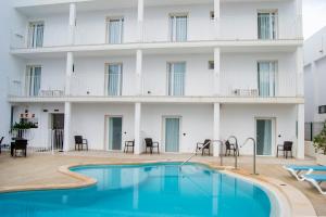 un hotel con piscina frente a un edificio en INNER Hotel Rupit "Adults Only" en Cala d´Or