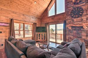 een woonkamer met een bank en een klok in een cabine bij Modern Cabin with Deck Near Zion National Park! in Duck Creek Village