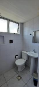 a white bathroom with a toilet and a sink at Pousada Temporada Atlântica in Fortaleza