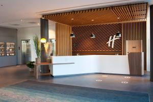a lobby with a reception desk in a building at Holiday Inn Paris CDG Airport an IHG Hotel in Roissy-en-France