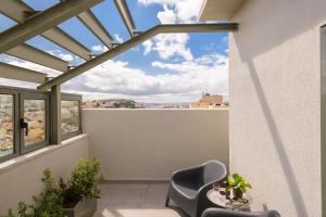 a balcony with two chairs and a table at Hotel Dom Carlos Liberty in Lisbon