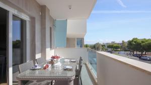 una mesa en un balcón con vistas a la calle en Dimora Paradiso, Monopoli, Puglia, Sea-View, Stylish, Family Friendly Home, en Monopoli