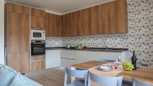 una cocina con mesa y sillas y una cocina con armarios de madera. en Dimora Paradiso, Monopoli, Puglia, Sea-View, Stylish, Family Friendly Home, en Monopoli