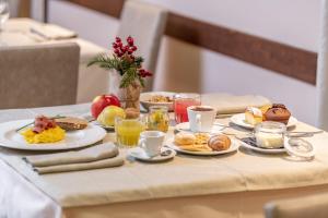 Una mesa con platos de comida para desayunar. en Hotel Italo, en Madonna di Campiglio 66 fotos más
