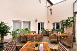 an outdoor patio with wooden tables and chairs at Cityhotel Bernburg in Bernburg