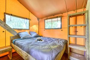 a bed in a tiny house with two windows at Camping maeva Escapades Millau Plage in Millau +51 photos