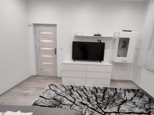 a living room with a tv on a white dresser at Apartament Sikorki in Nowy Sącz