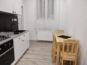 a kitchen with white cabinets and a table and chairs at Apartament Sikorki in Nowy Sącz