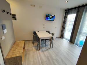 a room with a table and chairs and a tv at Residence Cristine in Riva del Garda