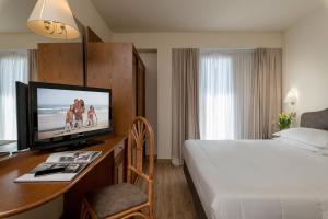 a hotel room with a bed and a desk with a television at Hotel Adlon - FRONTE MARE in Riccione