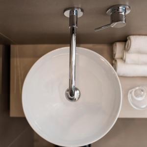 リッチョーネにあるHotel Adlon - FRONTE MAREの白いバスルームの洗面台(クロムの蛇口付)