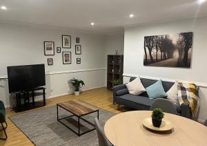 uma sala de estar com um sofá e uma mesa em Lovely 2 bedroom apartment with parking space em Londres