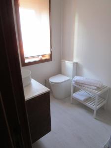 a white bathroom with a toilet and a window at The Artist´s Apartment in Espinho
