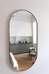uma cozinha com armários brancos e uma mesa num espelho em LION apartments - Premium STUDIO with balcony em Cracóvia