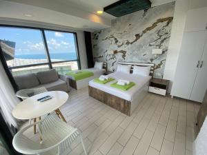 um quarto de hotel com uma cama, um sofá e uma mesa em Apartment In Porta Batumi Tower em Batumi