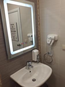 a bathroom with a white sink and a mirror at Three Dolphins Family Hotel in Varna City