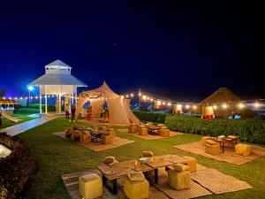 a tent with couches and tables in a field at night at Paradisus Cancun All Inclusive in Cancún