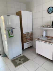 une cuisine avec un réfrigérateur blanc et un évier dans l'établissement Casa Temporada na Praia do Peró, à Cabo Frio