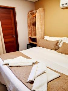 a white bed with two towels on top of it at Pousada Recanto in Fernando de Noronha