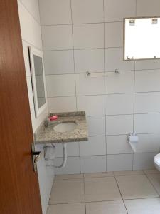 une salle de bain avec un lavabo et un miroir dans l'établissement Casa Temporada na Praia do Peró, à Cabo Frio