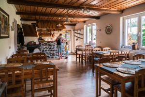 a woman standing in a room with tables and chairs at Penzion La Baita in Branná