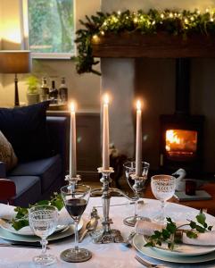 una mesa con velas, platos y copas de vino. en Elm Tree Cottage, en Fivemiletown