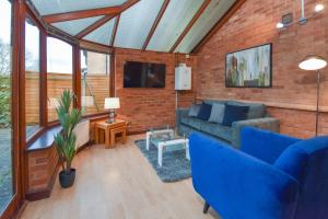 a living room with blue furniture and a brick wall at Silicon Court -Milton Keynes -4 bedroom Sleeps 7 in Milton Keynes