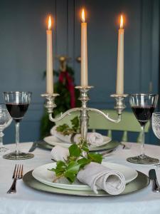 una mesa con velas, platos y copas de vino en Elm Tree Cottage, en Fivemiletown