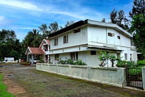 a white house with a fence in front of it at Thavihakklu Homestay 4BH, Kitchen, Coffee Estate in Chikmagalūr