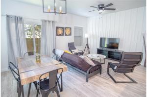 a living room with a table and chairs and a tv at Spectacular Cozy 3 BR plus 2 and a half BA Apt Near Downtown in San Antonio