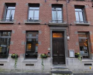 - un bâtiment en briques rouges avec une porte et des fenêtres dans l'établissement La Petite Histoire gîtes-appartements, à Ath