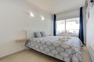 a bedroom with a bed and a window at Maison de la Mer by Innkeeper in Sesimbra