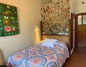 Casa Miguel Arcangel في كواتيبيك: غرفة نوم بسرير ودهان على الحائط