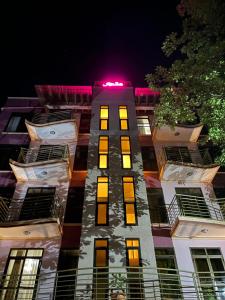 un grand bâtiment avec une lumière rouge au-dessus dans l'établissement Jaffa Suites, à Kampala