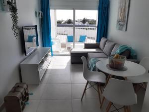 sala de estar con sofá, mesa y sillas en Marina Senator, en Costa Teguise