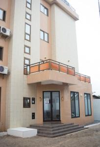 a building with a balcony on top of it at Hôtel Marbella in Lomé