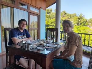 un hombre y una mujer sentados en una mesa en Blue Haven Guest House, en Kandy