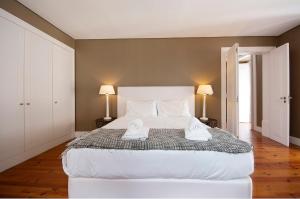 a bedroom with a large bed with two towels on it at Dockside Apartment by Innkeeper in Lisbon