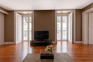 - un salon vide avec une télévision et des fenêtres dans l'établissement Dockside Apartment by Innkeeper, à Lisbonne
