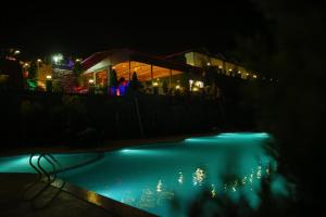 a swimming pool at night with a building in the background at HOA Resorts - Mountain View with Infinity Pool in Shivpuri