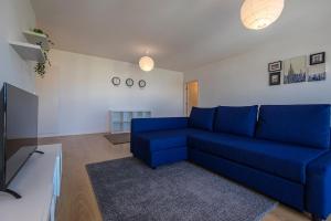 salon z niebieską kanapą i telewizorem w obiekcie Tranquil Retreat by Innkeeper w Lizbonie